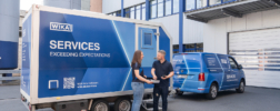 WIKA service employees standing in front of a mobile calibration van.