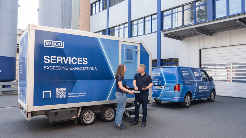 WIKA service employees standing in front of a mobile calibration van.