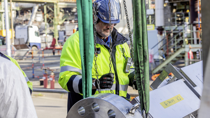 Service technician secured with personal protective equipment while working at an industrial site.