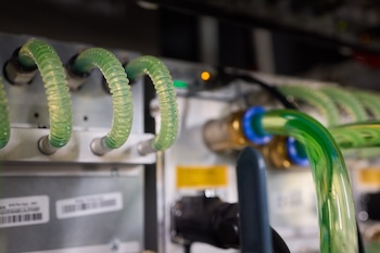 Vista detallada de un servidor moderno con tubos de refrigeración líquida que garantizan un control óptimo de la temperatura. Granja de minería de bitcoins
