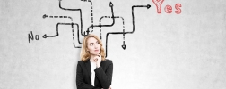 Portrait of a redhead woman standing near a concrete wall with arrows leading to yes, no or no answer. Concept of difficulties of making a choice I