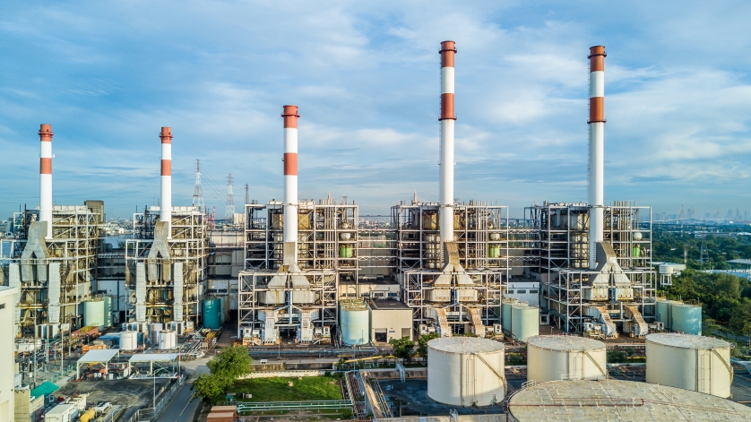 Wide shot of a power plant under a blue sky.