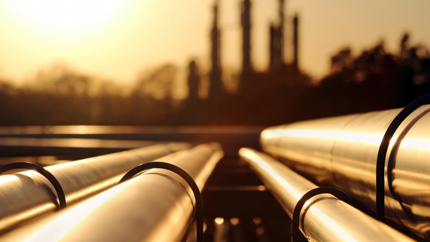 golden sunset in crude oil refinery with pipeline system